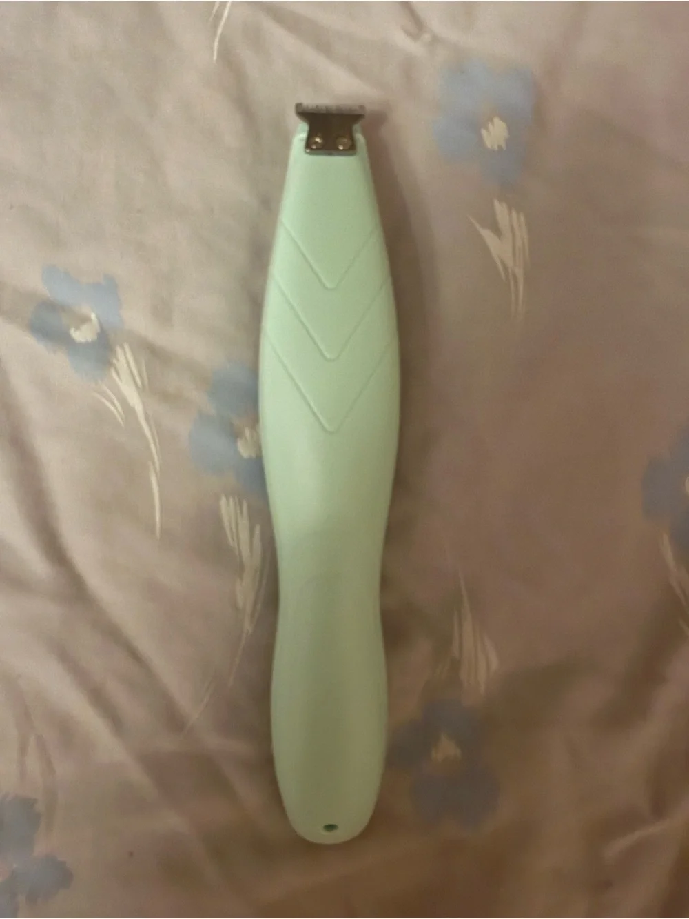 This a green electric pet shaver designed for trimming hair on dogs and cats.